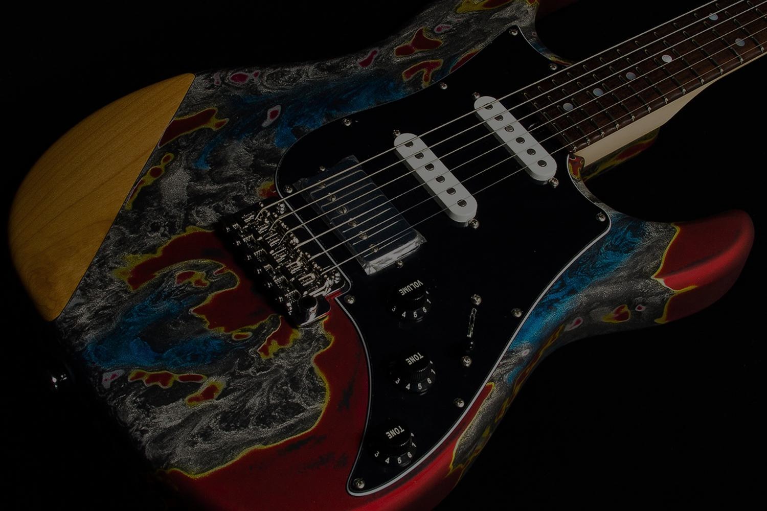 Close-up of a swirl-finished electric guitar body with black pickguard